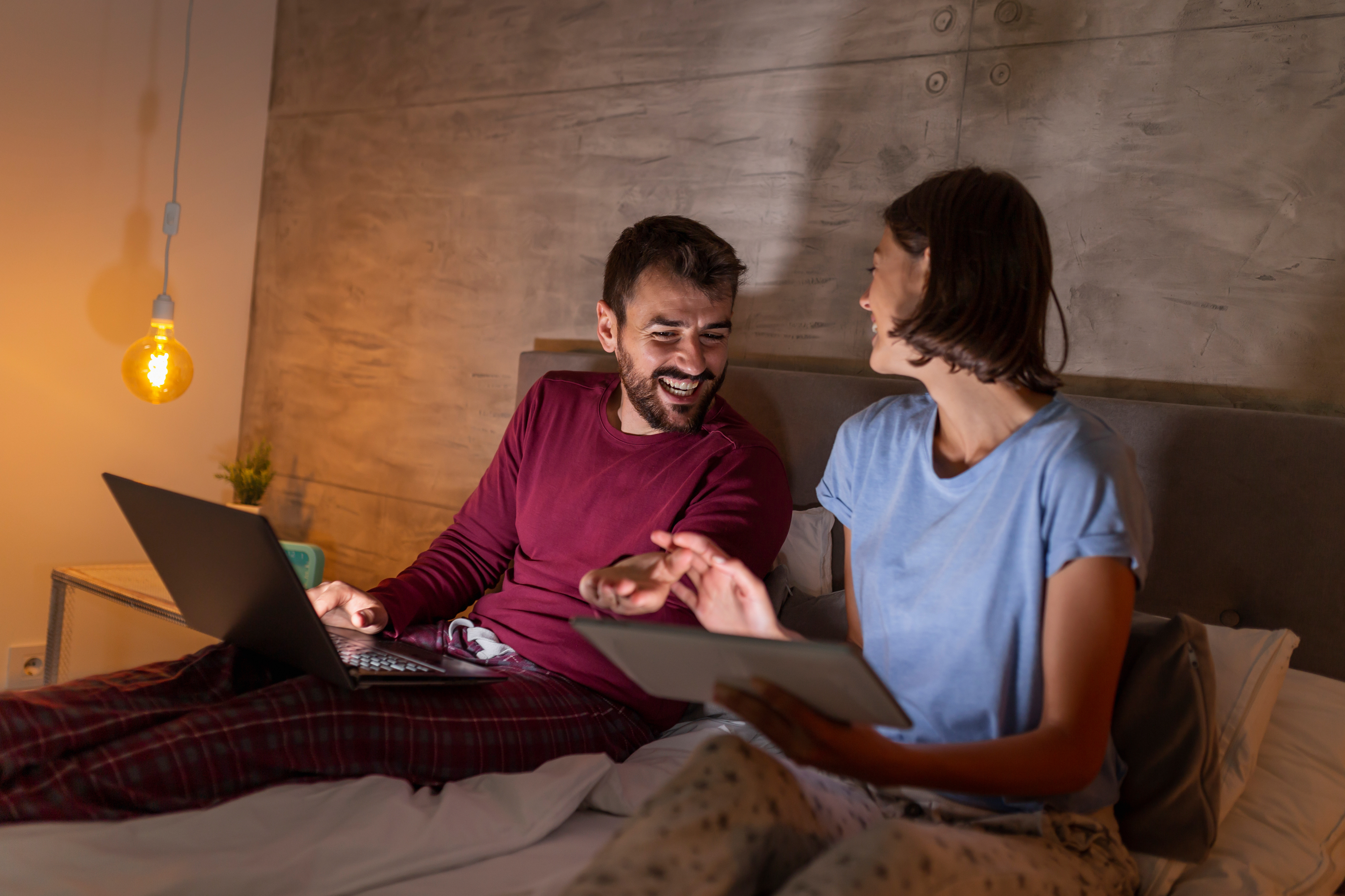 couple recherchant ses nouvelles vacances hôtel dans le lit le soir
